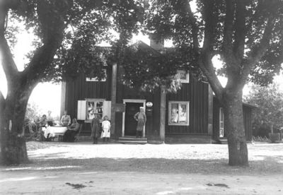 7 personer på gårdsplan framför byggnad
