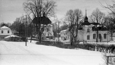 Ett antal byggnader i vintertid
Nyckelord: Hus