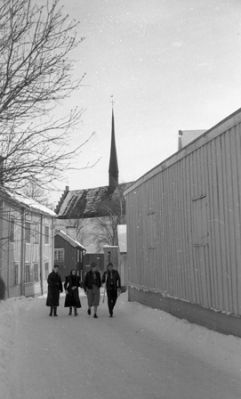 4 personer gående på snöig gata
