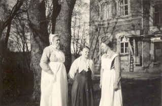 3 kvinnor framför större byggnad
Nyckelord: Dräkt