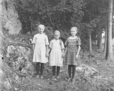 3 flickor stående i naturen
Nyckelord: Dräkt