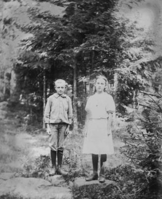 Pojke och flicka stående i skogen
Nyckelord: Dräkt