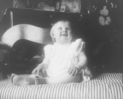 Liten flicka sittande i rum
