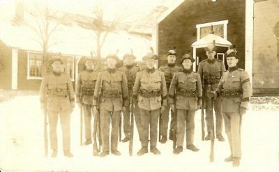 Militärer med gevär stående framför byggnader
Nyckelord: Uniform Gevär