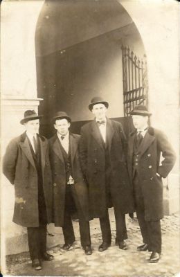 4 män stående framför valv
