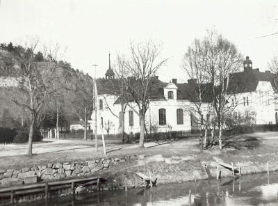 Två stora byggnader intill vattendrag
