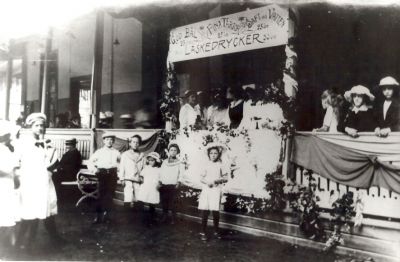 Festklädda barn och vuxna vid stor uteveranda
Nyckelord: Dräkt Skylt