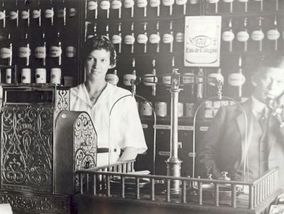 Kvinna och man bakom disken i färghandel
Nyckelord: Kassaapparat Balansvåg Telefon