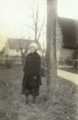 Kvinna stående i park med kyrka i bakgrunden
