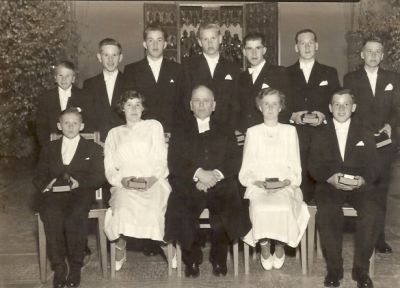 Präst omgiven av en grupp konfirmander
Nyckelord: Dräkt Bibel Psalmbok