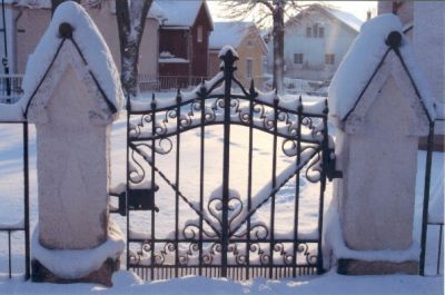Järngrind med stadsbebyggelse i bakgrunden

