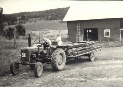 Traktor med lass framför ladugård
Nyckelord: Traktor Höhässja