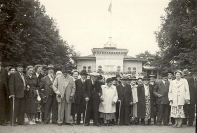 En grupp äldre människor framför byggnad
