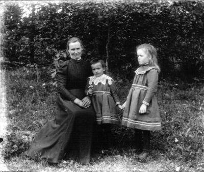 Kvinna och 2 flickor i trädgård
Nyckelord: Dräkt