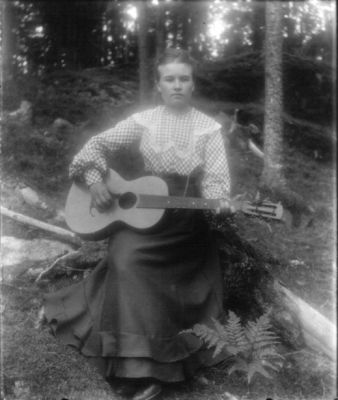 Kvinna med gitarr sittande i skogen
Nyckelord: Gitarr Dräkt