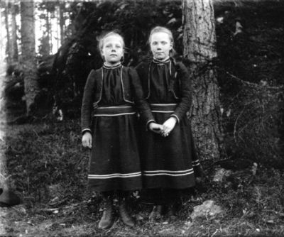 2 flickor stående i skogen
Nyckelord: Dräkt