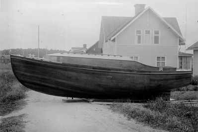 Båt på gata framför byggnad
Nyckelord: Båt