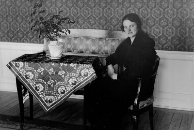 Kvinna sittande i rum
Nyckelord: Tapet