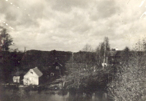 Vit byggnad vid vattendrag
