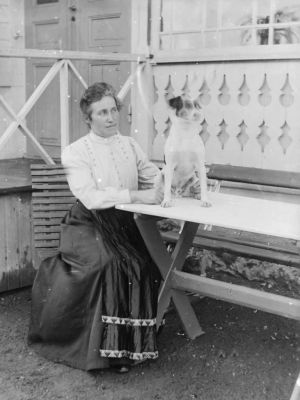 Kvinna med hund vid trädgårdsbord
Nyckelord: Hund
