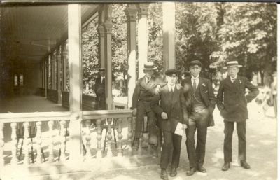 4 ynglingar vid veranda
Nyckelord: Skolmössa Hatt Klockkedja