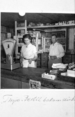 Kvinna och man bakom affärsdisk
Nyckelord: Lanthandel;Våg