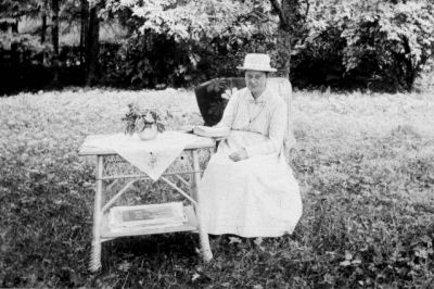 Kvinna sittande vid trädgårdsmöbel
Nyckelord: Hatt