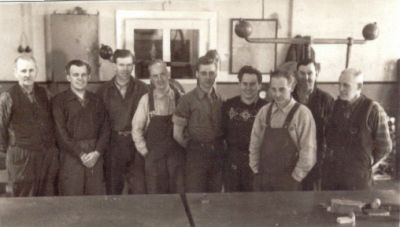 En grupp arbetsklädda män i lokal
