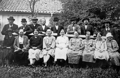 Män och kvinnor framför byggnad
