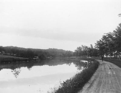 Man stående på väg intill vattendrag
