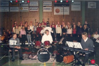 Orkester och sångkör i sporthall
