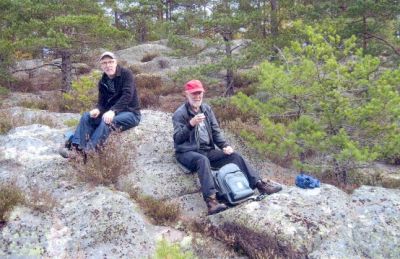 2 män sittande på berg
