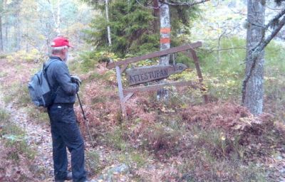 Man stående vis skylt på naturled
