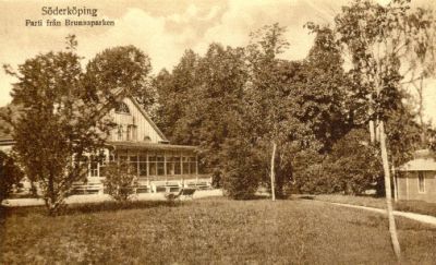 Byggnad med glasveranda i parkområde
