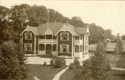 Stor trävilla omgiven av park
