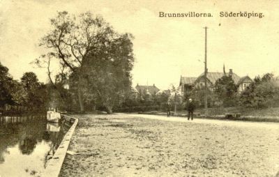 Stora trävillor i parkområde invid vattendrag
