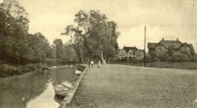 Stora trävillor i parkområde invid vattendrag
