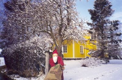 Tomte vid gult hus
