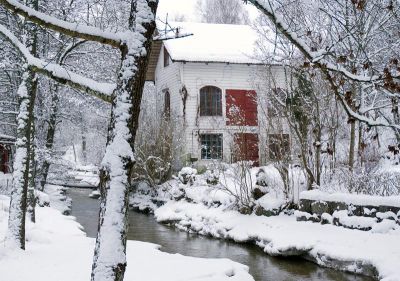 Vit byggnad intill vattendrag
