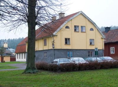 Putsad ljusgul byggnad med hög stenfot
