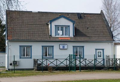 Vit träbyggnad med blå fönsterfoder
