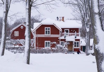 Röd och vit villa intill park
