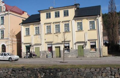 Gul putsad byggnad utmed vattendrag
