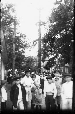 Ett antal personer samlade vid midsommarstång.
Nyckelord: Midsommarstång