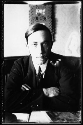 Man sittande i rum med pipa i munnen.
Nyckelord: Pipa