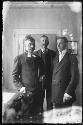 3 män stående i rum.
Nyckelord: Dörr