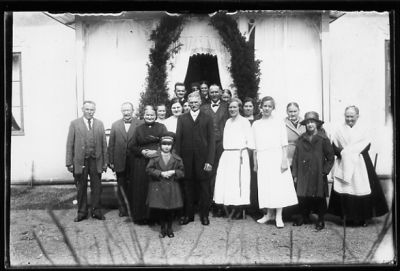 Ett antal personer stående framför portal på byggnad.
Nyckelord: Portal