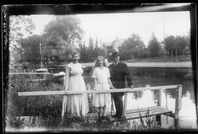 Man och 2 kvinnor stående på brygga i vattendrag.
Nyckelord: Brygga Båt