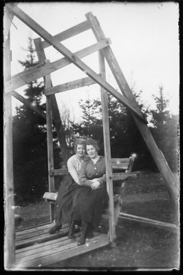 2 kvinnor sittande i slänggunga.
Nyckelord: Slänggunga