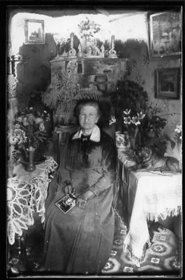 Kvinna sittande i rum.
Nyckelord: Blommor Tavla